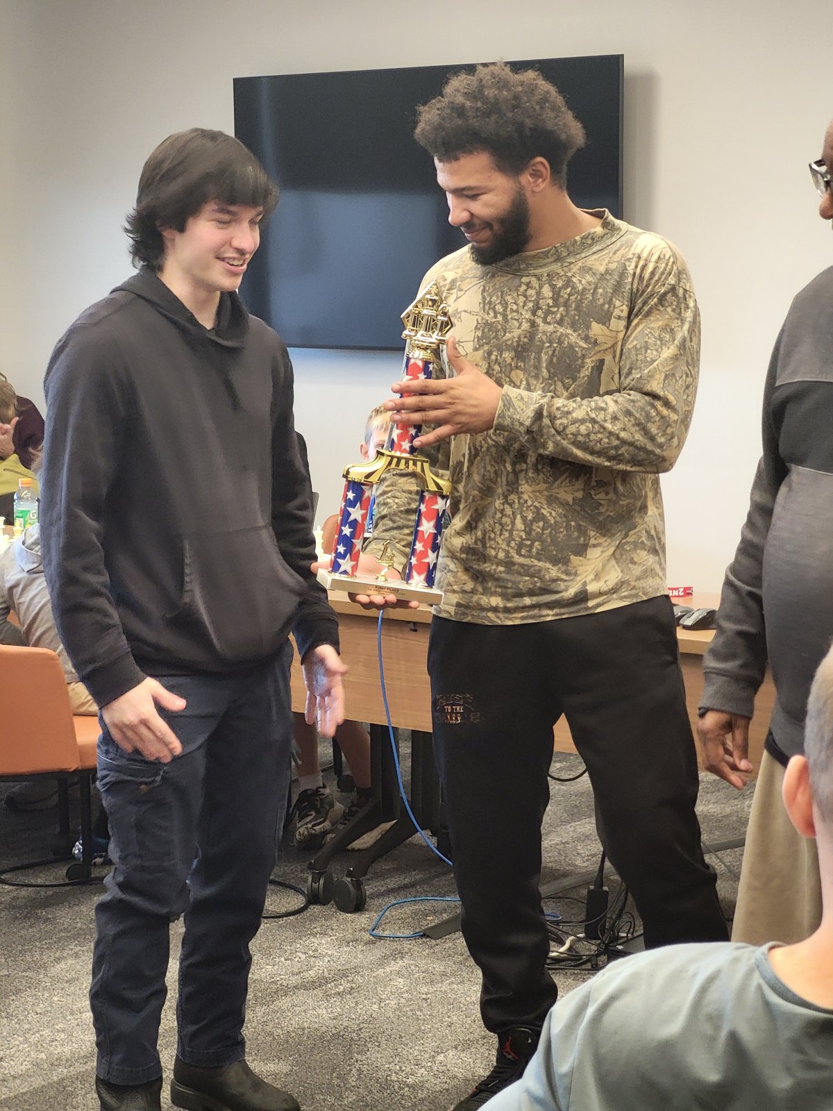 First-place bughouse team holding the trophy at the Trager Family JCC Chess Classic